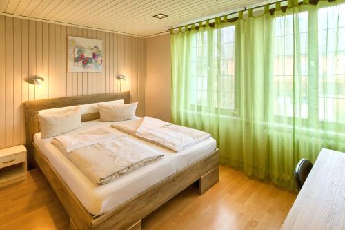 布赖斯高地区施陶芬索内酒店的一间卧室配有一张带绿色窗帘的大床