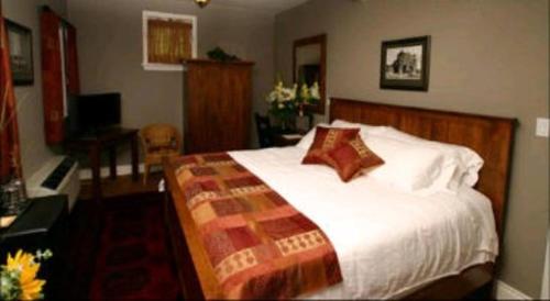 帕里桑德海边宾馆的一间卧室配有一张大床和一张书桌