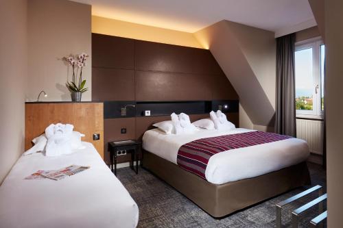 科尔马欧洲酒店的酒店客房设有两张床和窗户。