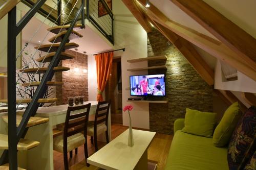 兹拉蒂博尔天然木别墅酒店的客厅配有绿色沙发和电视