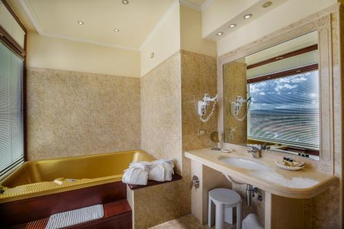 奥尔比亚全景酒店的浴室配有黄色浴缸和水槽