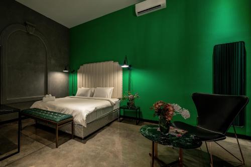 胡志明市HOTEL le JARDIN SECRET saigon的绿色卧室,配有床和绿色的墙壁