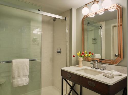 牛津牛津毕业生酒店的浴室配有盥洗盆和带镜子的淋浴