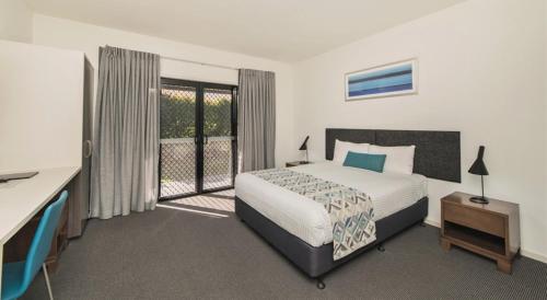洛坎普顿Quality Resort Parkhurst的一间卧室设有一张床和一个阳台