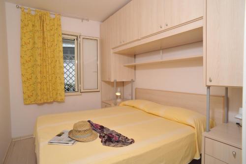 维耶斯泰Residence Le Orchidee的一间卧室,配有一张床,上面有帽子