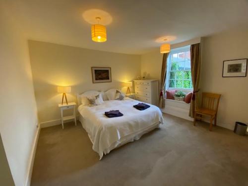 PewseyStunning 3 bedroom 3 bath self catering cottage near Stonehenge Avebury and Bath Great village pub的卧室配有白色的床和窗户。