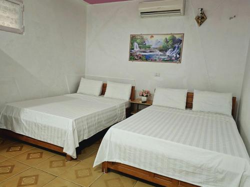 洞海Homestay 117 Bà Triệu - Đồng Hới的白色墙壁客房的两张床