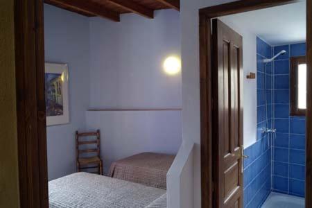菲内斯特拉特Casa Figueretes的一间卧室配有一张床,浴室设有淋浴。