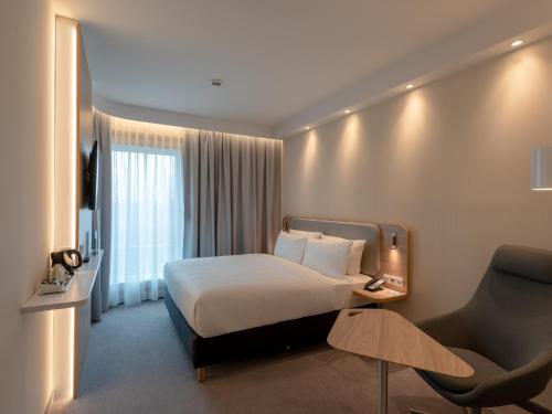 慕尼黑Holiday Inn Express - MUNICH NORTH, an IHG Hotel的配有一张床和一把椅子的酒店客房