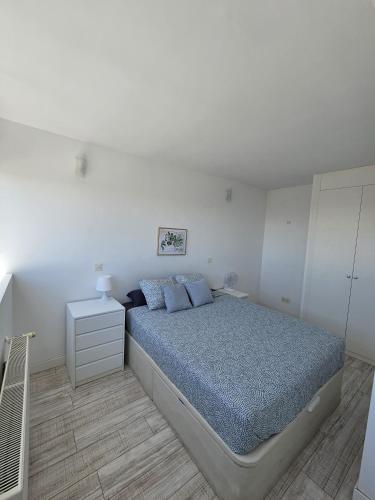 马德里Cómodo apartamento en Madrid的白色卧室配有床和白色橱柜