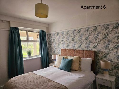 斯凯格内斯Beach Court Holiday Apartments的一间卧室配有一张带绿色窗帘的床