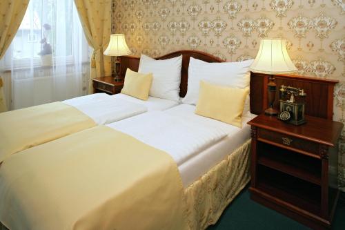 霍穆托夫Hotel MERTIN的一间卧室配有一张带两个白色枕头的大床