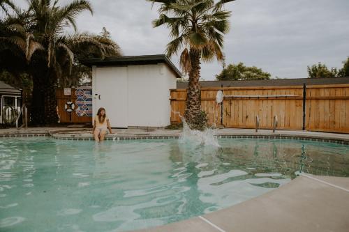 雷德布拉夫Triangle Motel的坐在游泳池的水中的女人