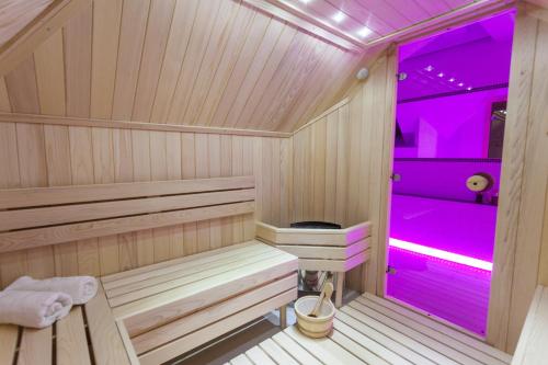 兹拉蒂博尔维拉保罗沃克水疗酒店的一间房间内的木制桑拿房,配有紫色照明