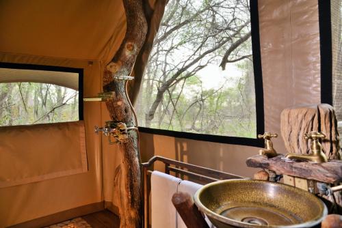 斯库库扎丛林漫步之旅酒店的一间带水槽和树窗的浴室