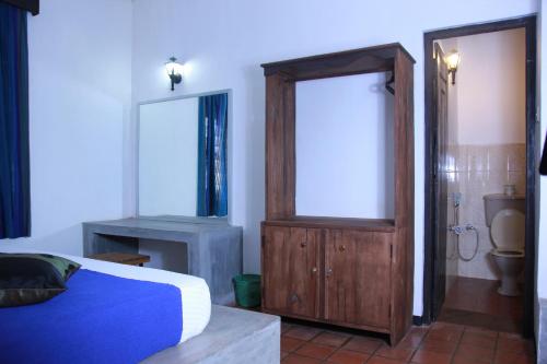 丹不拉Dambulu Oya Family Park的一间卧室配有一张床,浴室设有卫生间