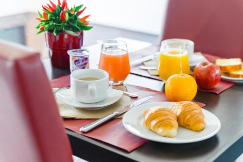 斯特拉斯堡斯特拉斯堡威尔逊拉格朗日公寓式酒店的一张桌子,早餐包括羊角面包和橙汁