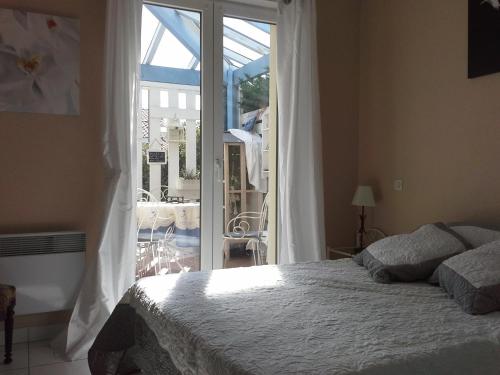 卡布勒通Chambre Privée Chez l'Habitant的一间卧室设有一张床和一个滑动玻璃门