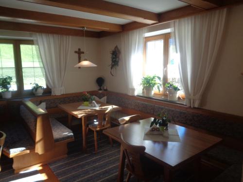 奇勒谷地拉姆绍Jogglerhof的餐厅设有桌椅和窗户。