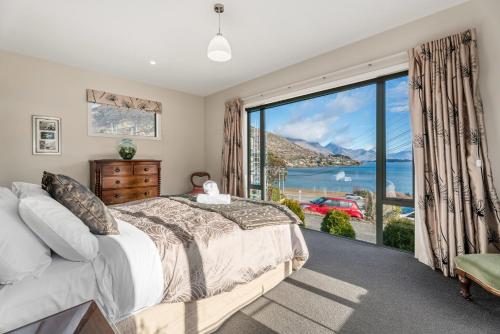 皇后镇Frankton Arm Vista - Queenstown Holiday Home的一间卧室设有一张床和一个大窗户