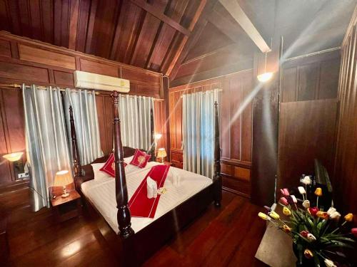 琅勃拉邦Luang Prabang Charming Boutique Hotel的卧室配有一张床铺,位于带木墙的房间内