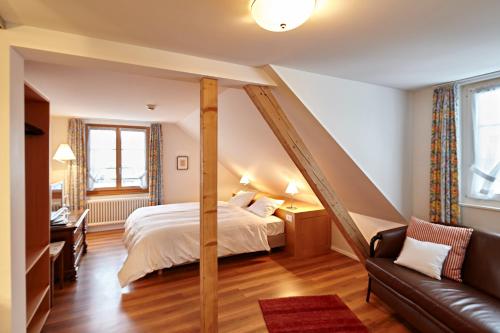 卢塞恩兰德嘎斯霍夫罗斯里酒店的一间卧室配有一张床和一张沙发