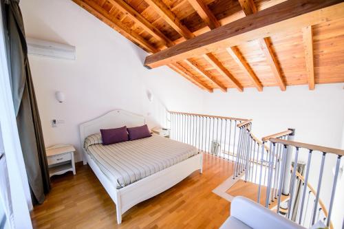 新西普里亚诺普辛帝aCasaMia Resort的客房设有一张床和一个带木制天花板的楼梯。