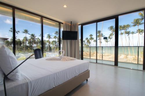 马塞约Maceio Mar Resort All Inclusive的一间卧室配有一张床,享有海滩美景