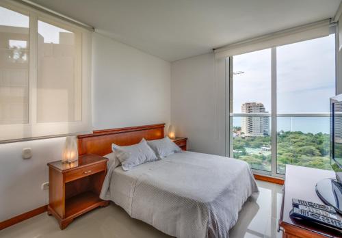圣玛尔塔Apartamento - Condominio Zazué的一间卧室设有一张床和一个大窗户