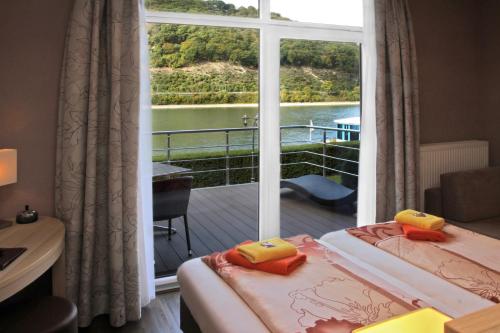 坎普-博尔恩霍芬莱茵国王酒店的客房设有两张床和一个带窗户的阳台。