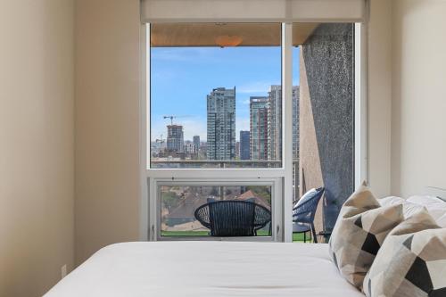 卡尔加里Heart of Downtown Calgary Spacious Luxury Condo with Stunning Views and Premium Amenities的一间卧室设有一张床和一个大窗户