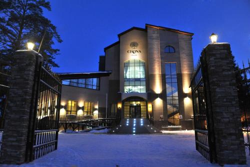 别尔茨克科罗娜酒店及SPA的一座在夜间有雪门的建筑