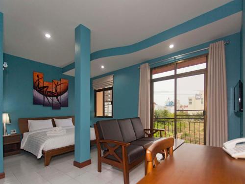 南芭堤雅芭堤雅花园公寓精品酒店的卧室配有床、椅子和窗户。