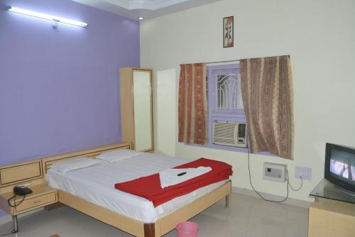 DarbhangaHotel Naveen Residency的一间卧室设有一张床、一台电视和一个窗口。