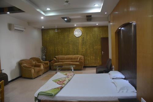 DarbhangaHotel Naveen Residency的一间卧室配有一张床,客厅配有沙发