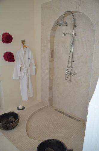 比塞大Dar Salama的浴室设有淋浴,墙上有白色的长袍