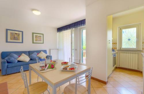 雷卡纳蒂港Residence I Giardini Del Conero的客厅配有桌子和蓝色沙发