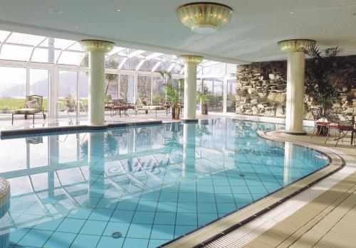 基拉尼阿多伽海茨温泉酒店的一座设有柱子和窗户的大型游泳池