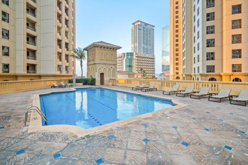 迪拜Sunkissed holiday homes 2 and 4 BR Apartments on JBR beach near mall & metro & bluewaters Island的一座位于城市中心,拥有建筑物的游泳池