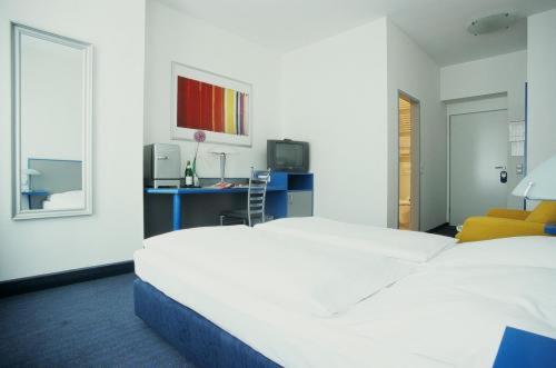 柏林特格尔阿尔特酒店的卧室配有一张白色大床和一张书桌
