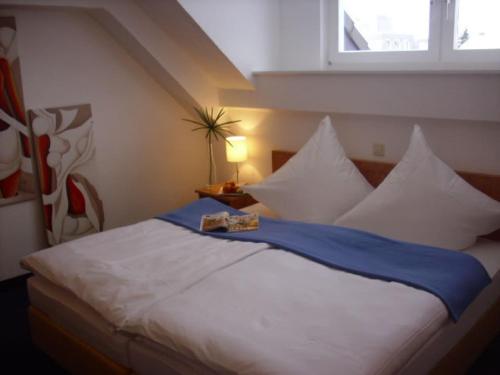 维利希加尼怎特拉尔酒店的卧室配有一张带白色枕头的大床和窗户。