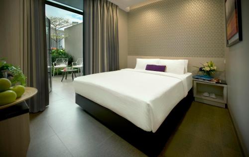 新加坡V Hotel Bencoolen的一间带一张白色大床的卧室和一个阳台