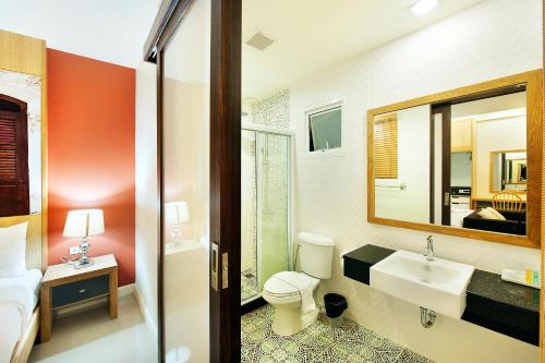 普吉镇Ratana Hotel Rassada - SHA Extra Plus的一间带卫生间、水槽和镜子的浴室
