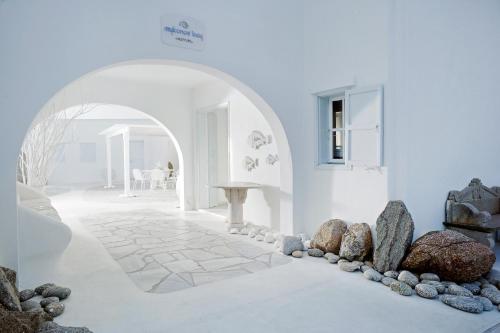 米克诺斯城米科诺斯湾度假酒店&别墅 的白色客房,设有石地板和拱门