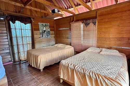 巴拿马城Private Cabin Over the Water PLUS Meals - San Blas Islands - private bathroom的木墙客房的两张床