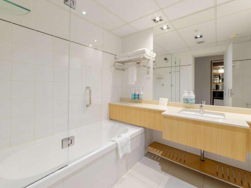 悉尼达令港诺富特悉尼酒店的带浴缸、水槽和镜子的浴室