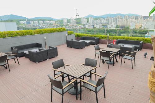 城南市Hotel Skypark Central Seoul Pangyo的屋顶上带桌椅的天井