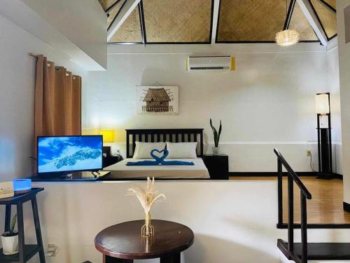 大雅台Kavanah Suites Tagaytay-Villa 3的一间卧室配有一张床和一张带电脑的书桌