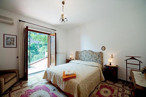 波西塔诺埃斯特索尔别墅酒店的一间卧室设有一张床和一个大窗户