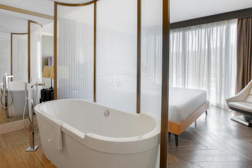 洛杉矶喜来登环球酒店的配有床铺的客房内的白色浴缸